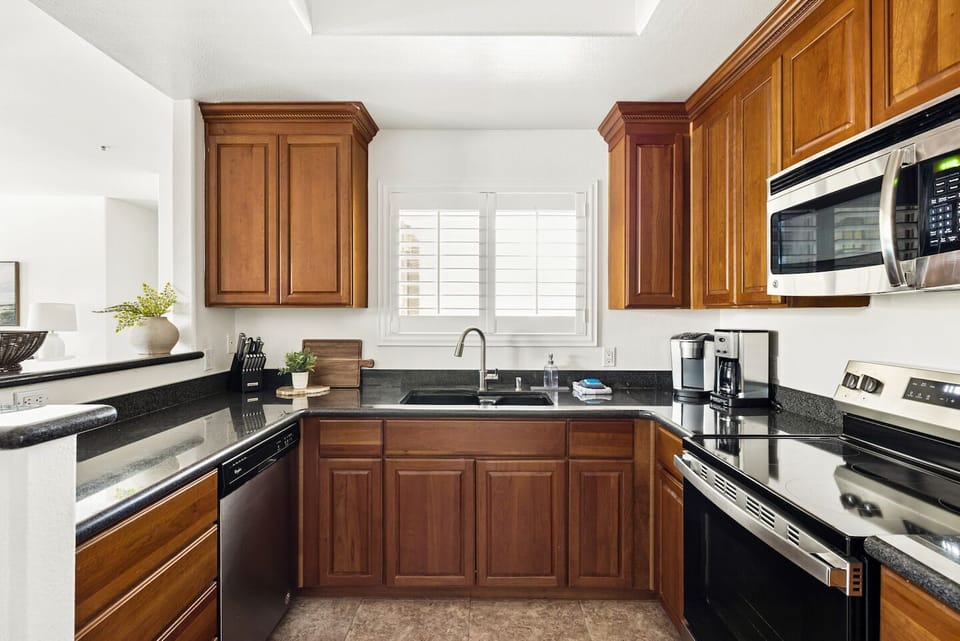 Bright full kitchen with stainless appliances and coffee setup