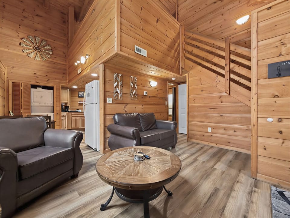 Cozy wood cabin lounge with loft staircase and open-concept charm