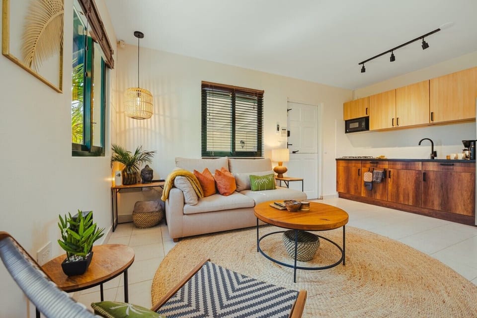 Open and full of character, this stylish space connects a cozy lounge and warm wooden kitchen for easy tropical living.