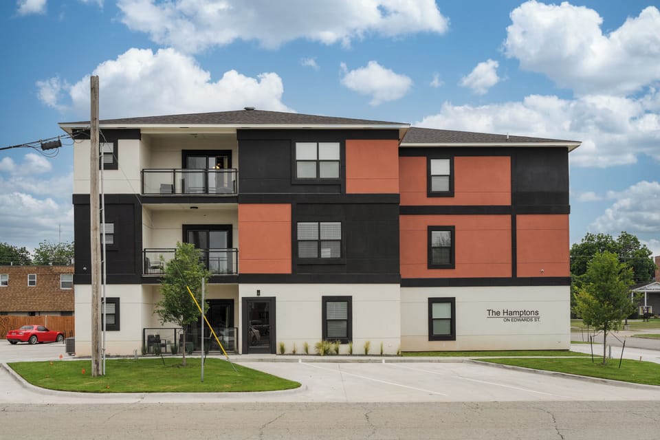 Modern apartment exterior with balconies, parking, and stylish curb appeal