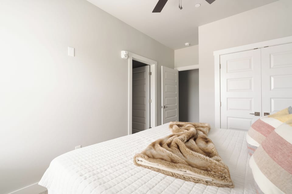 Bright, modern bedroom with high ceilings and cozy neutral touches