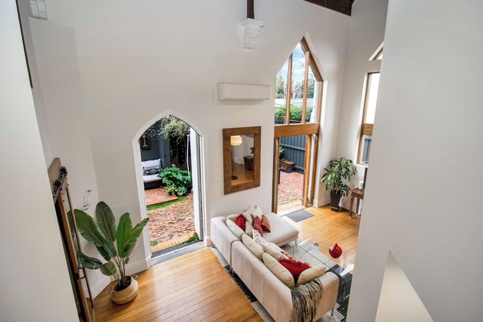 Soaring ceilings and arched windows overlooking a charming brick courtyard