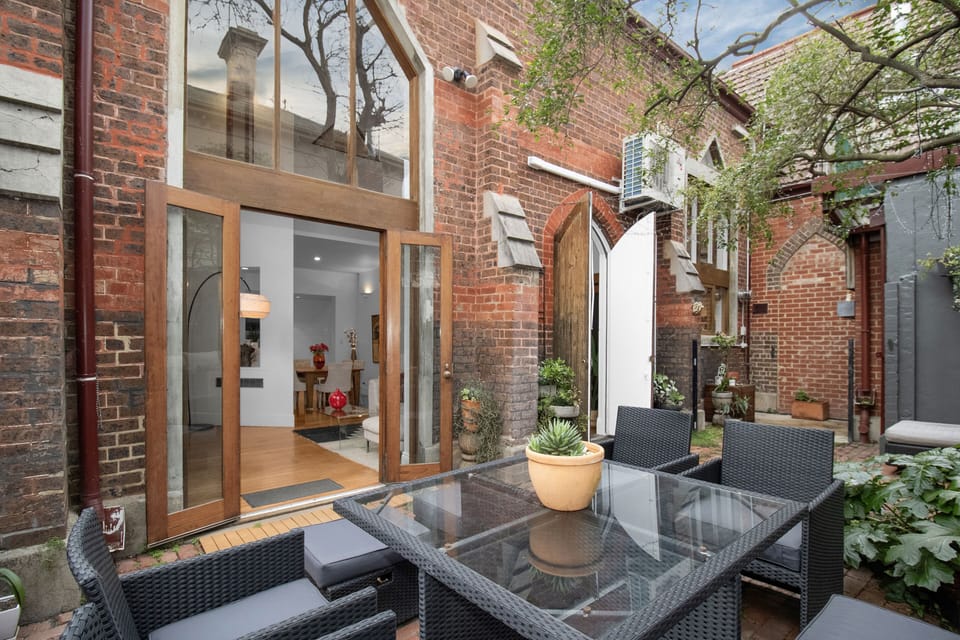 Charming brick courtyard with alfresco dining and indoor-outdoor flow