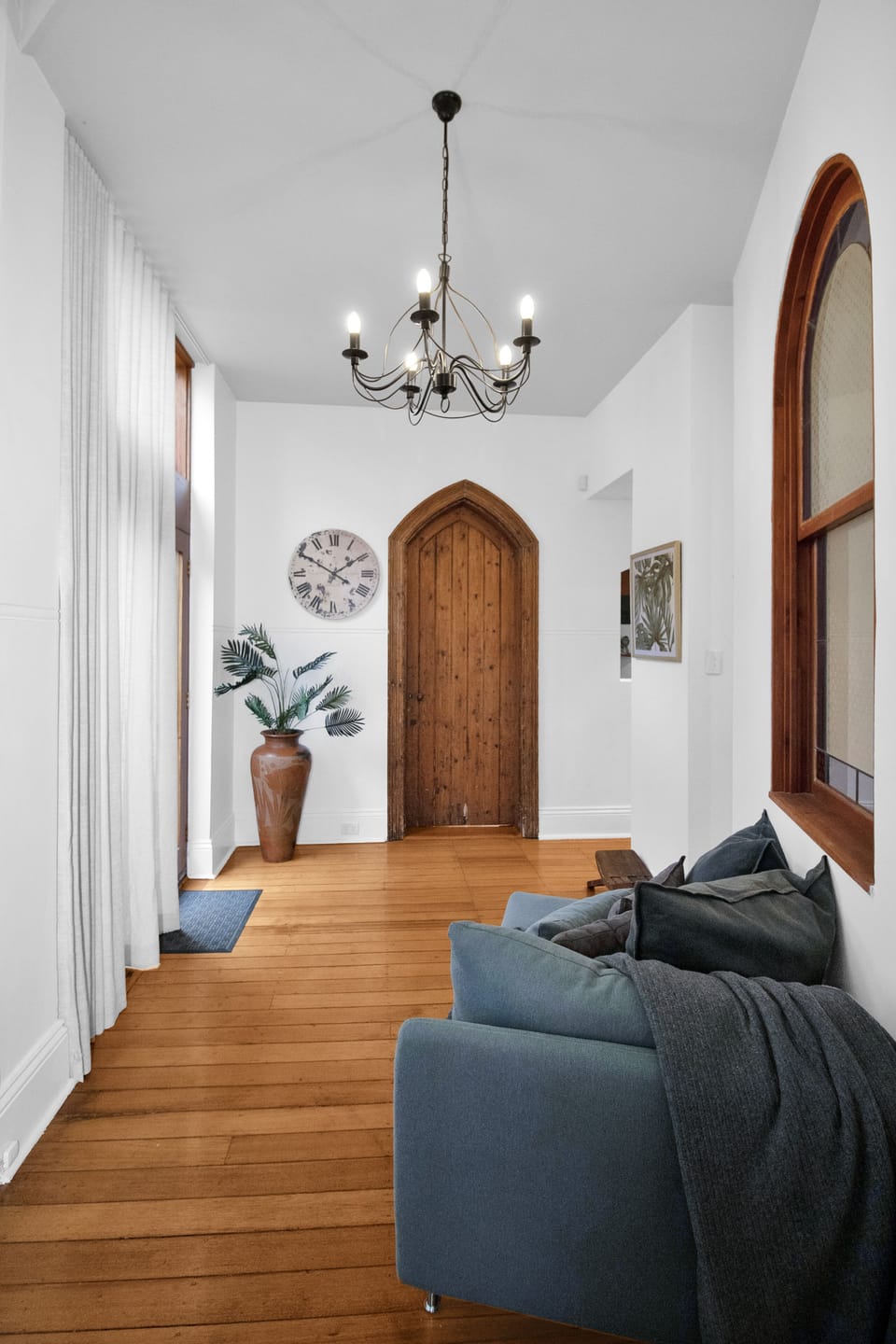 Bright, elegant entry hall with soaring ceilings and a charming arched door