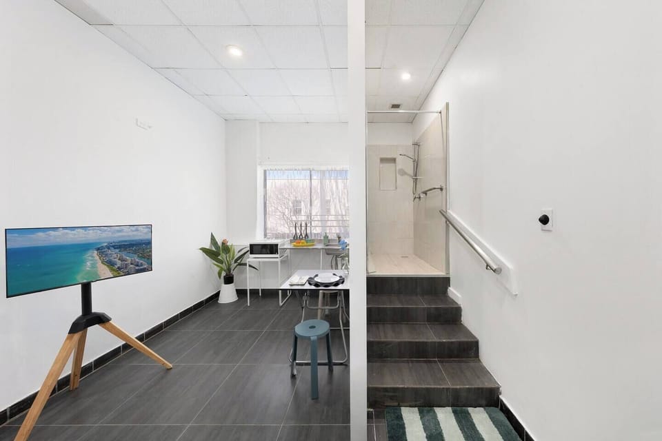 Bright modern studio space with sleek tile floors and walk-in shower