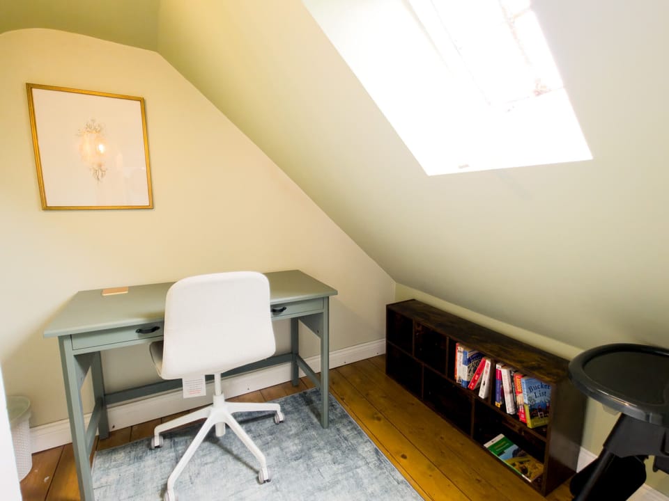 A desk under the roof light with books and games on the shelf below. Somewhere to work, or to keep the children busy on a wet afternoon.