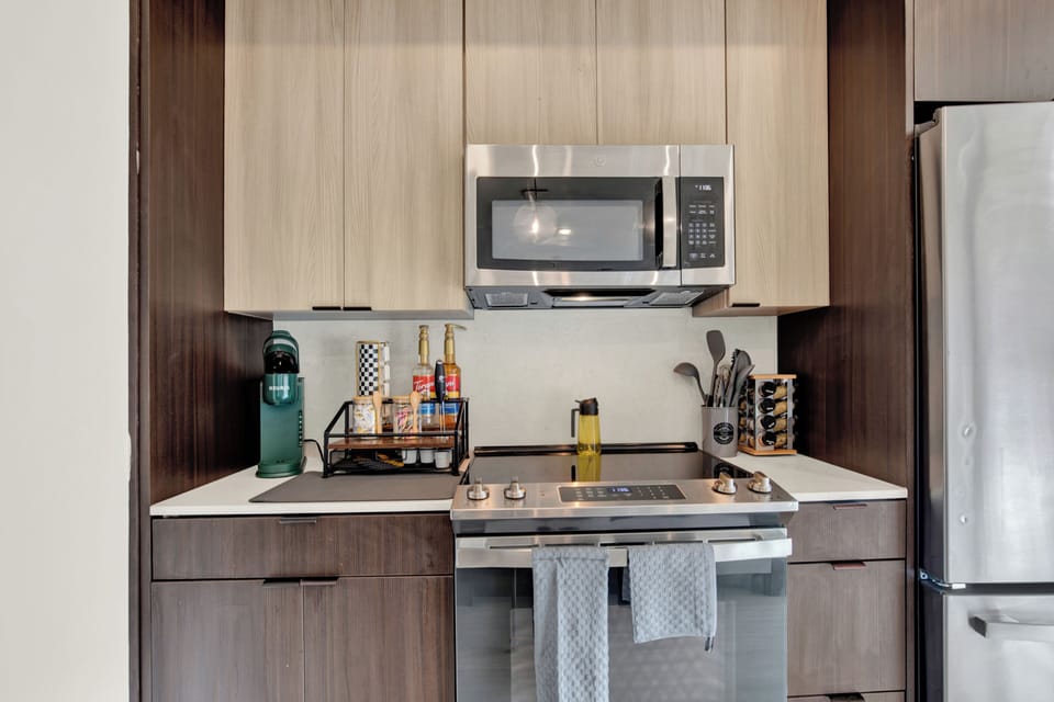 Modern kitchen with stainless appliances, coffee station, and sleek finishes