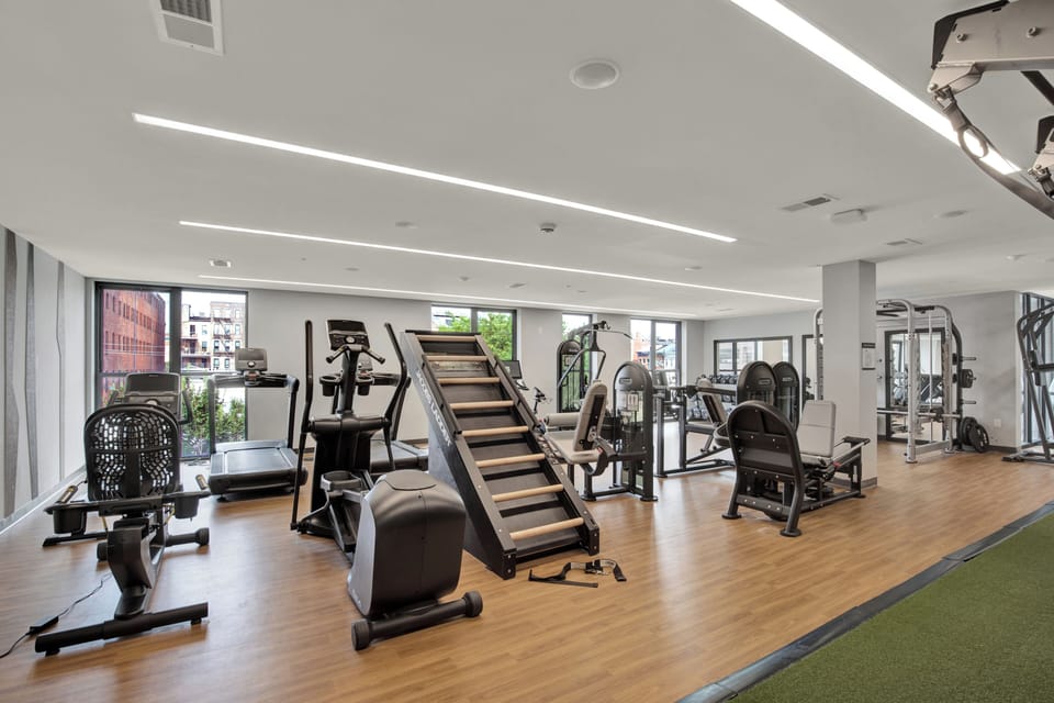 Bright modern fitness center with cardio, strength equipment, and natural light