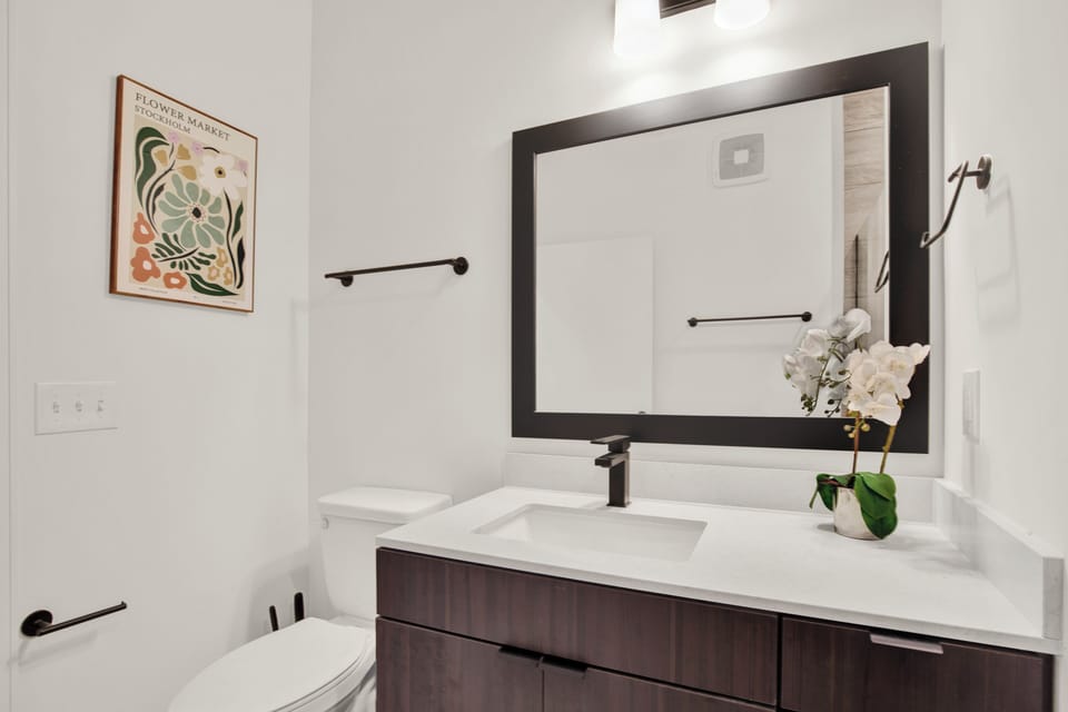 Bright modern bathroom with sleek vanity, large mirror, and stylish finishes