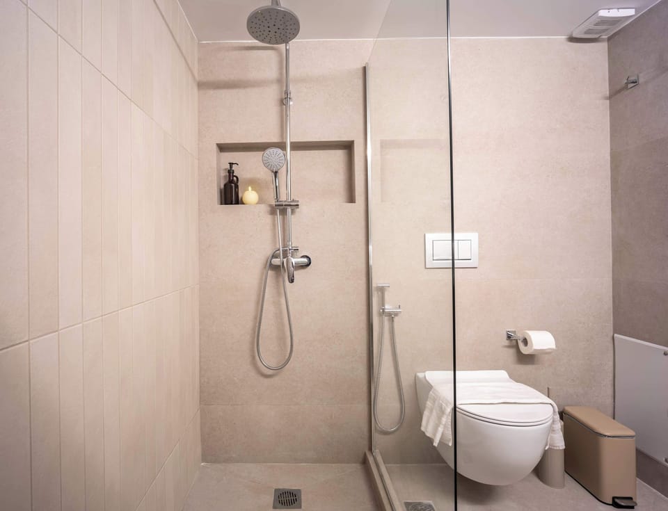 Wash away travel fatigue under a rainfall shower head inside this sleek tiled space.