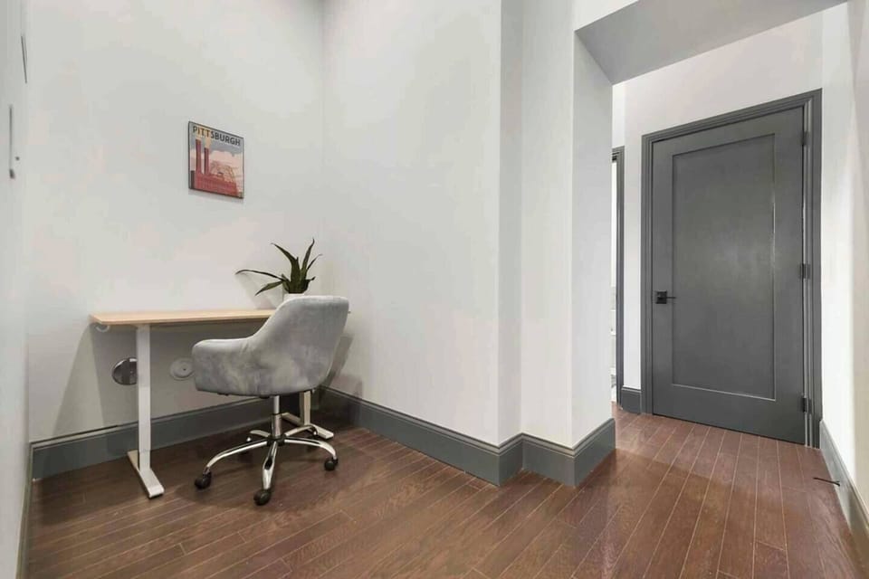 Quiet hallway workspace with sleek desk, comfy chair, and modern finishes