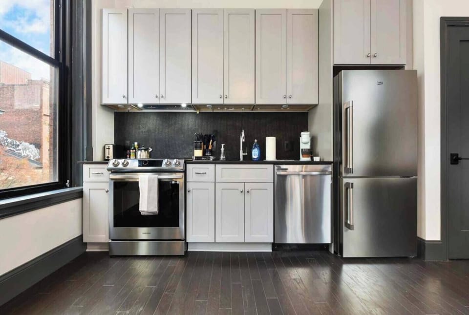 Bright modern kitchen with stainless steel appliances and tall cabinetry