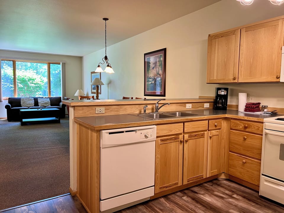 Bright open kitchen with breakfast bar and sunny living room views
