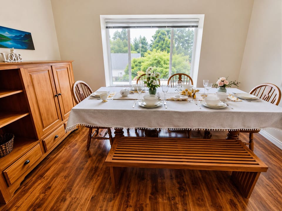 Bright dining room with large window, elegant table setting, and warm wood accents
