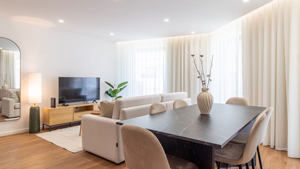Unwind in the spacious living area with comfortable seating and a large TV, or gather around the stylish dining table for memorable meals with friends and family. Soft curtains ensure privacy while letting in abundant natural light.