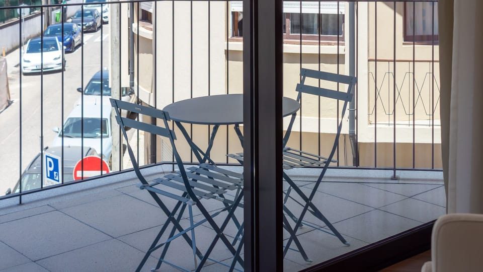 Imagine starting your day with a fresh coffee on this private balcony, taking in the lively street scene below. It's the perfect spot for an evening drink, offering a serene escape with an urban pulse.