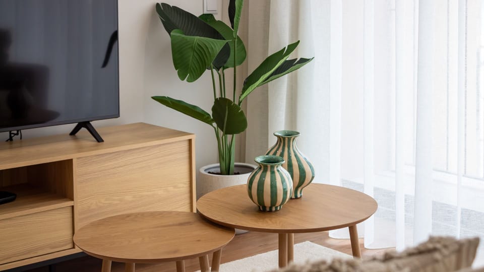 Unwind in the inviting living area, bathed in natural light, where a modern TV and stylish decor create a perfect space for relaxation after a day of exploration. The thoughtful design ensures comfort and aesthetic pleasure, making you feel right at home.