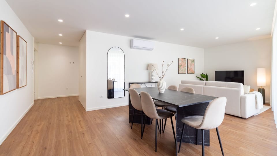 Gather with loved ones in this bright and spacious open-plan living and dining area, featuring a sleek dining table perfect for shared meals and a comfortable sofa for unwinding after a day of exploration. Abundant natural light enhances the room's modern