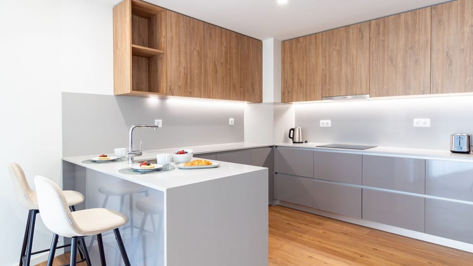 Prepare delicious meals in the fully equipped, contemporary kitchen, boasting sleek integrated appliances and a stylish island with bar seating for casual dining or morning coffee. The bright under-cabinet lighting creates an inviting atmosphere for cooki