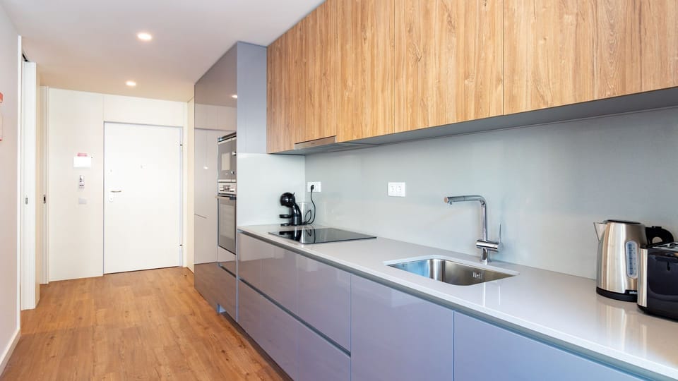 The fully equipped, streamlined kitchen awaits your culinary adventures, featuring a contemporary sink, sleek induction hob, and all the essentials for preparing delicious meals. Enjoy the ease of a modern cooking space designed for both functionality and