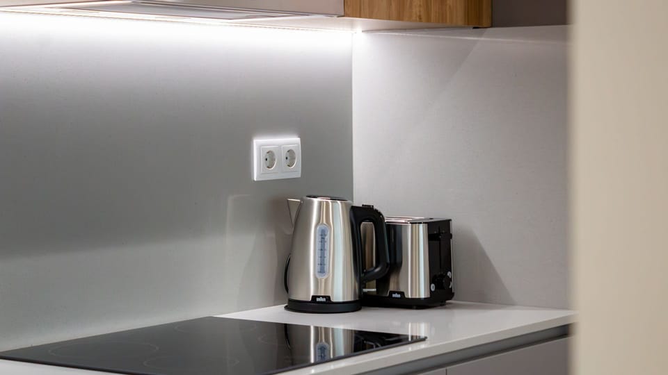 Enjoy the convenience of a well-appointed kitchen, where a modern induction hob, kettle, and toaster make preparing quick breakfasts or warming up snacks effortless. Everything you need for a comfortable stay is at your fingertips. #KitchenEssentials #Mod