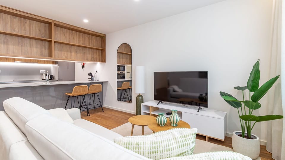 Unwind in this comfortable living area, thoughtfully designed for relaxation and entertainment, with a large TV perfect for movie nights or catching up on shows. The adjoining kitchen island with stylish bar stools offers a casual spot for breakfast or ev