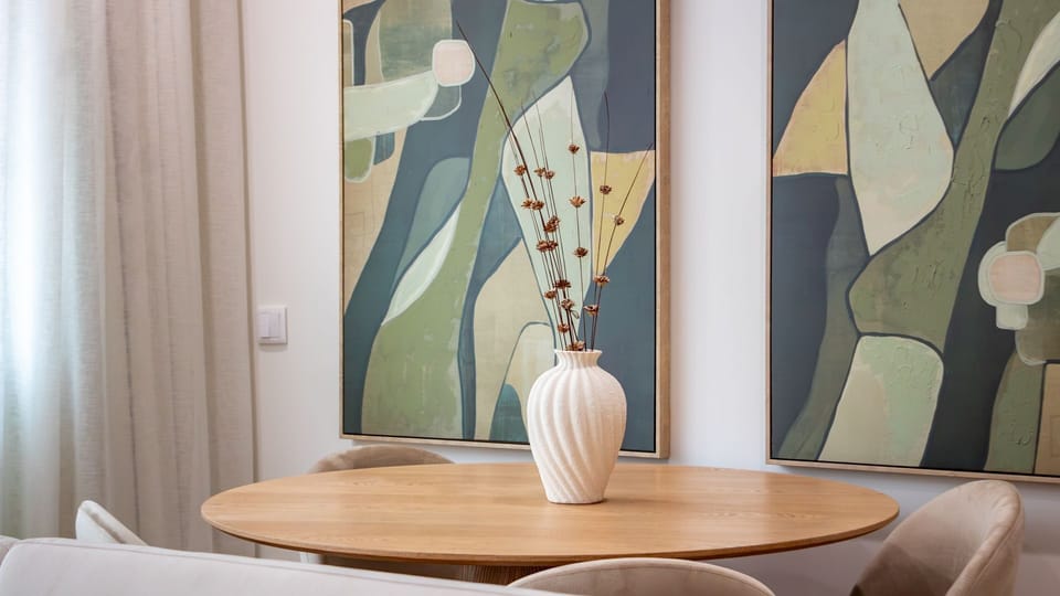 Gather around this stylish dining table for memorable meals and conversations, enhanced by chic abstract art that adds a touch of sophistication to your stay. The inviting ambiance makes every dining experience feel special. #DiningArea #ModernDesign #Abs