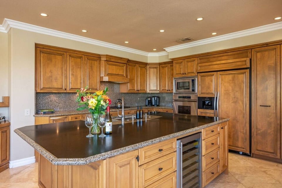 Fully stocked kitchen: stainless steel appliances and large island, wine fridge