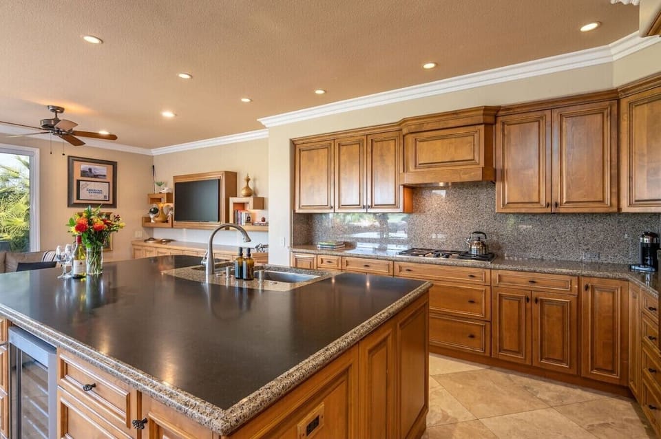 Fully stocked kitchen: stainless steel appliances and large island, wine fridge