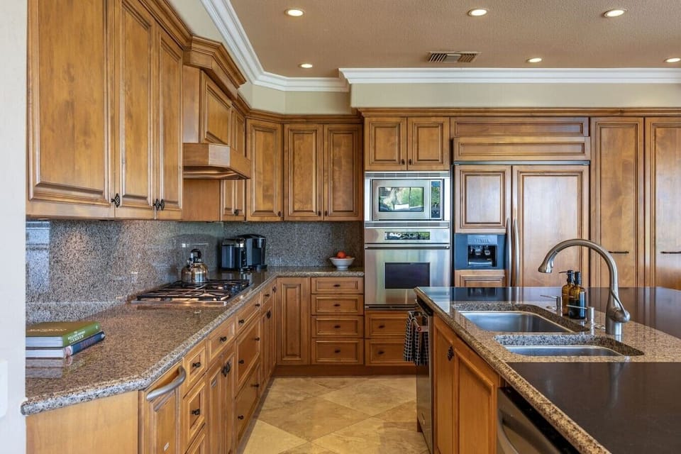 Fully stocked kitchen: stainless steel appliances and large island, wine fridge