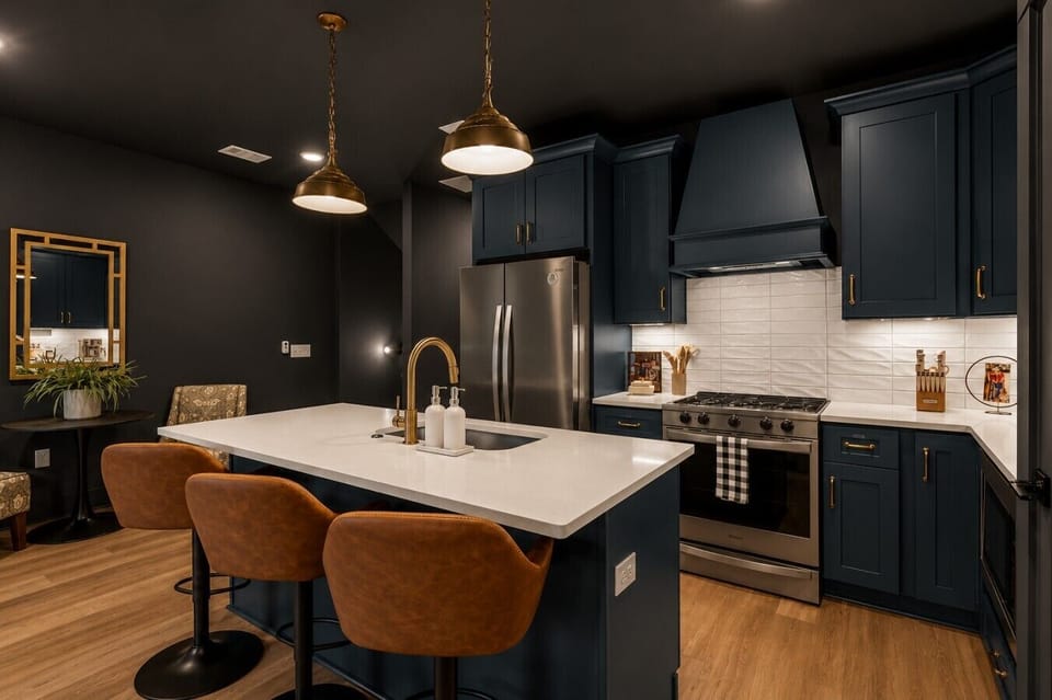 Gourmet kitchen oasis with deep teal cabinetry and sleek brass accents.