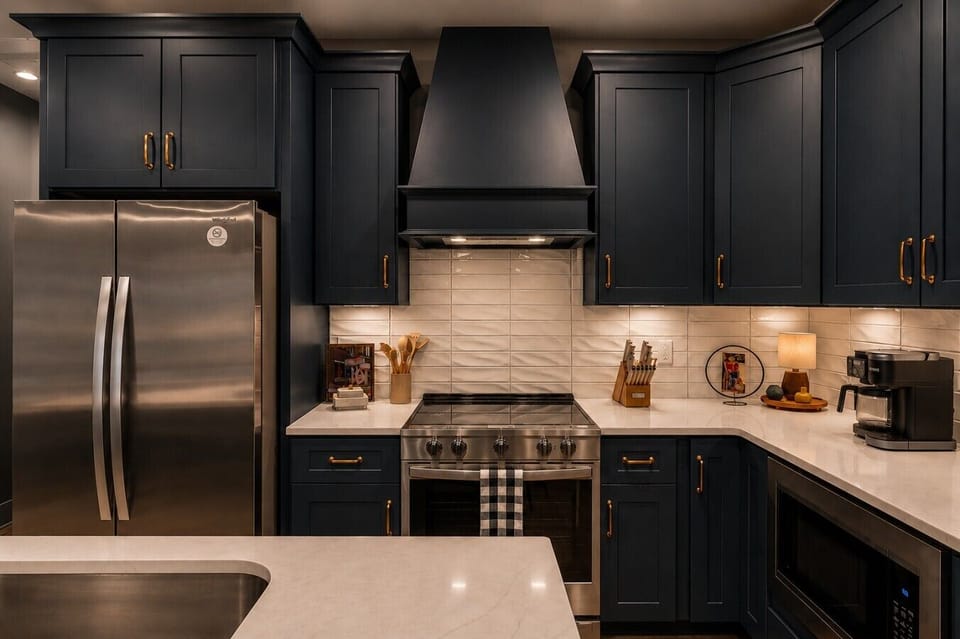 Fully equipped guest kitchen complete with a French-door fridge and gold hardware.