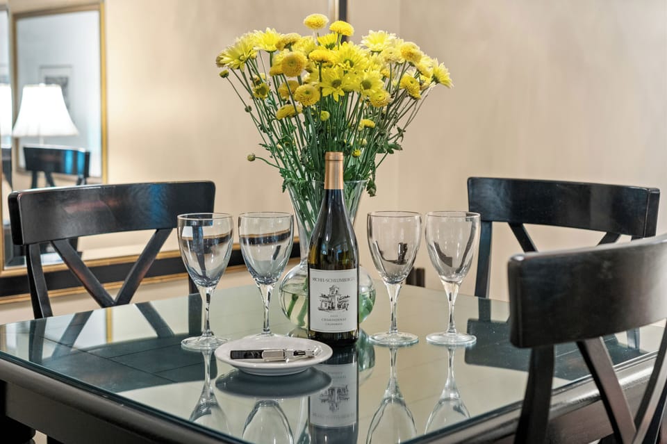 Inviting dining setup with wine, fresh flowers, and elegant seating