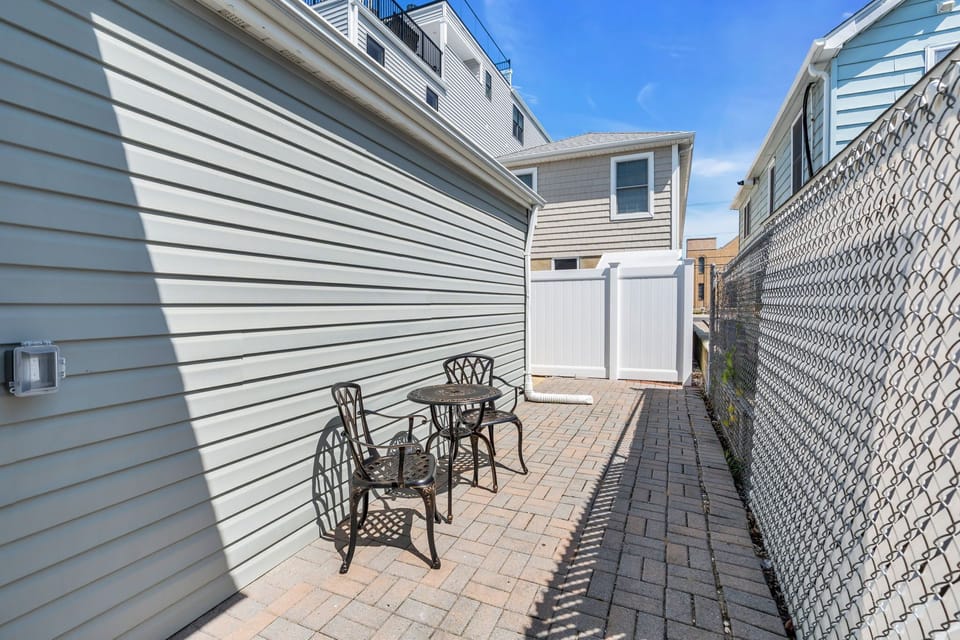 Sunny private patio with bistro seating and paved walkway