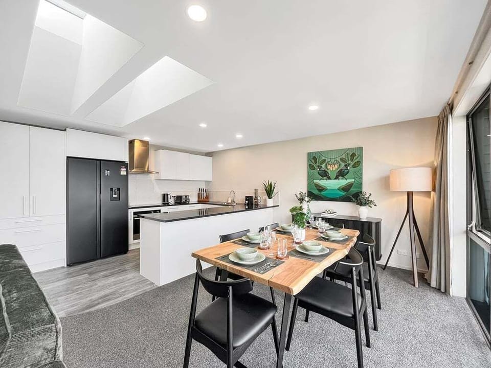 Bright, open-plan kitchen and dining space with modern appliances, sleek cabinetry and mountain views.