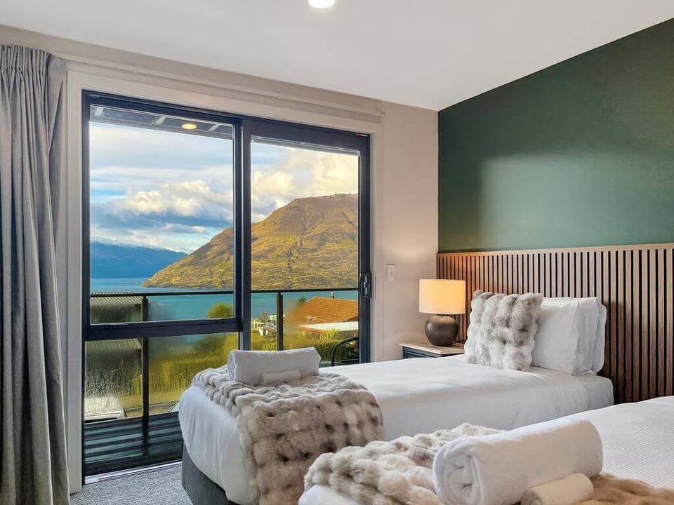Twin bedroom with sliding doors opening to lake and mountain views