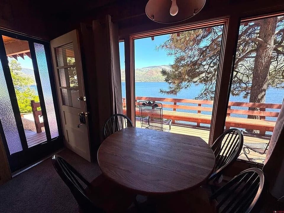 Dining table with seating for 4, in the living room, with views of the lake.