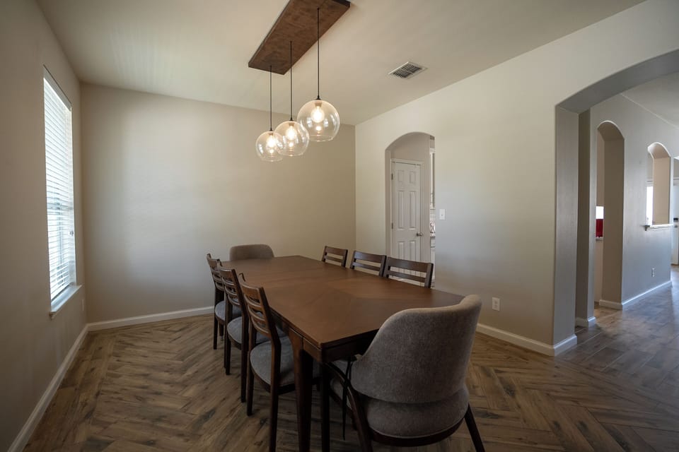 Bright dining room with seating for 6 and stylish pendant lighting