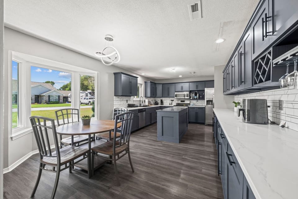 Gather around this cozy breakfast table tucked in a sunlit bay window, with the fully equipped kitchen just steps away.