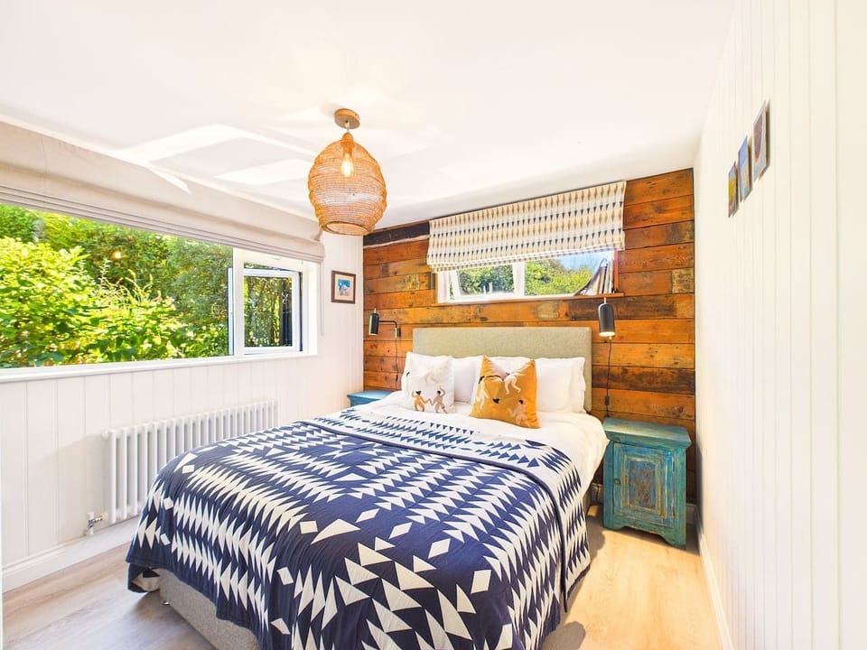 Rest easy in the restful double bedroom, dressed in navy prints and warmed by natural light from the garden.