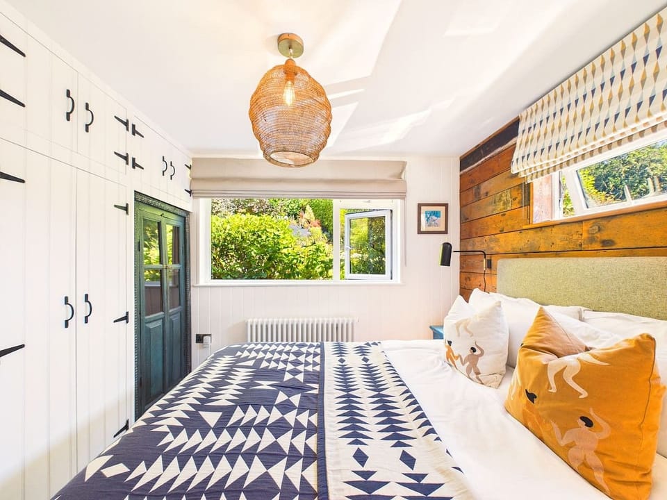Wake to garden views in this serene bedroom, where woven textures and crisp linens invite a proper lie-in.