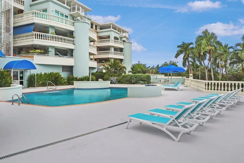The communal pool complete with an outside shower and sun loungers.