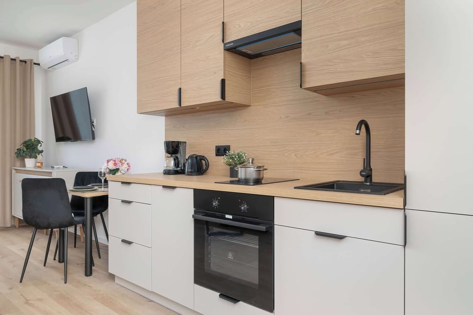 Another angle of the kitchen highlighting the cooking area, oven, countertop, and wood-finish cabinets.