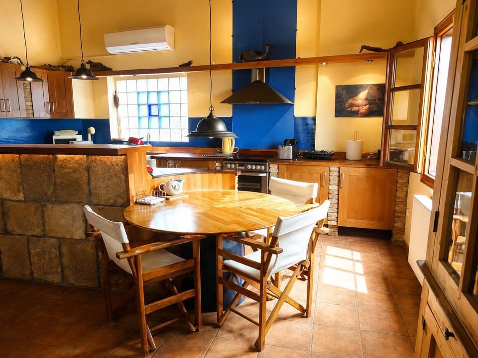 A warm, traditional kitchen and dining area with wooden furniture, tiled floors and plenty of natural light, perfect for preparing meals throughout your stay