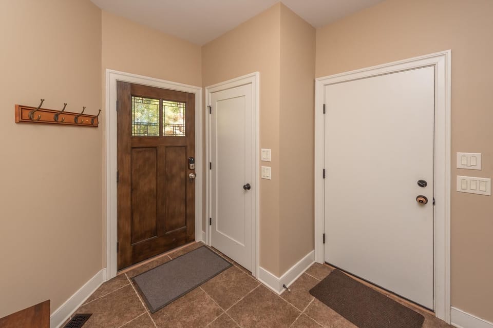 Tiled entry foyer with coat hooks.