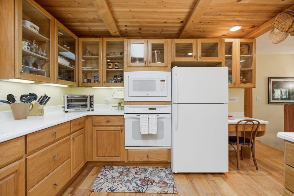 Kitchen | Glass Front Cabinets & White Countertops | Wood Beam Ceiling