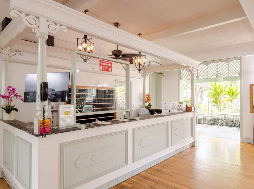 Reception counter with decorative woodwork and an open entrance to the patio.