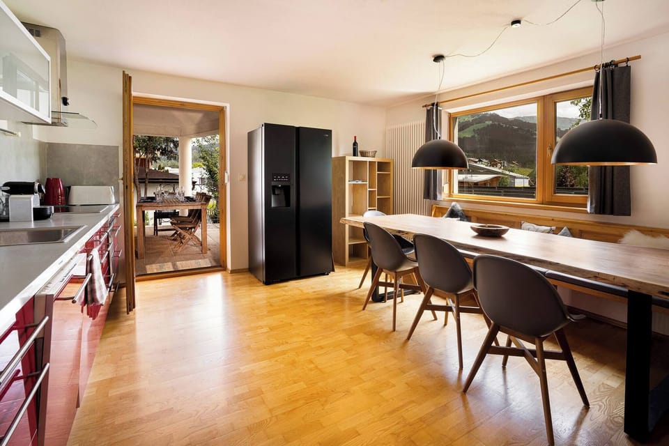 ully equipped kitchen with large dining table at KitzAlps Standard Apartment, ideal for self-catering families and groups in Kirchberg.