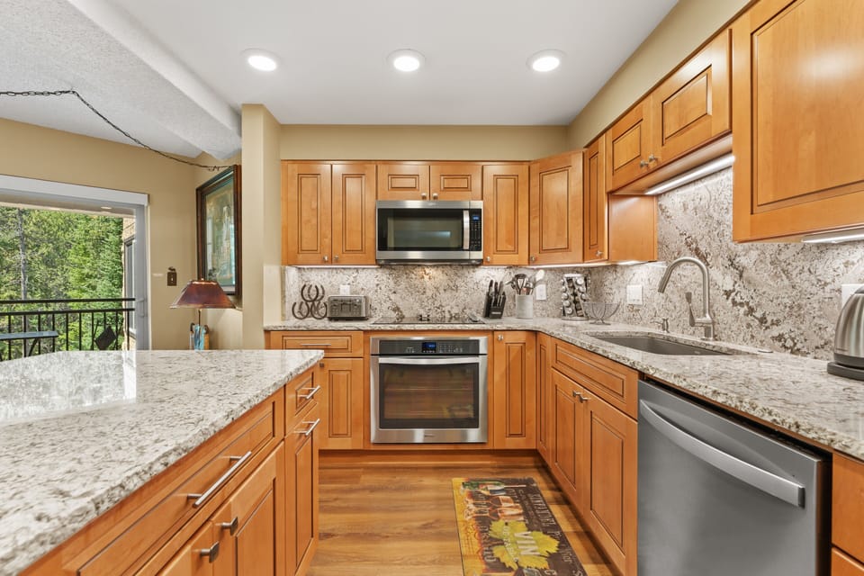 Your kitchen is ready for every culinary adventure with granite countertops, stainless steel appliances, and warm wood cabinetry that invites you to gather and create memorable meals.