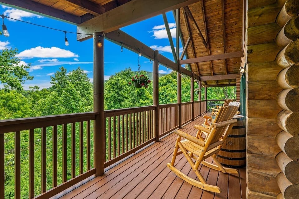 Pour your first morning coffee out here with the whole group, nothing moving but the trees — this deck is where the Smoky Mountain trip actually begins.